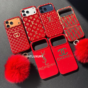 Rotes Design mit goldenem Buchstaben und Fellbommel